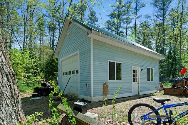 view of side of home featuring metal roof and an outdoor structure
