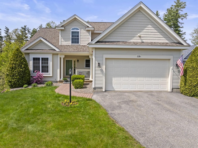 traditional-style house with asphalt driveway, an attached garage, a shingled roof, and a front lawn