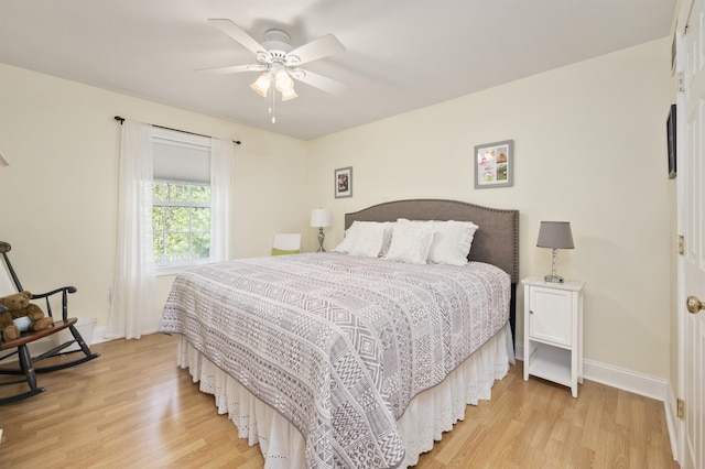 bedroom with light wood-style floors, baseboards, and a ceiling fan