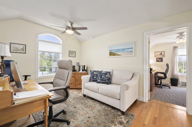 office area featuring a ceiling fan, vaulted ceiling, healthy amount of natural light, and light wood finished floors