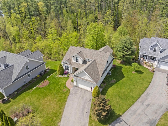 aerial view of property and surrounding area featuring a heavily wooded area