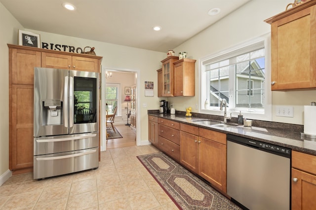 kitchen with stainless steel appliances, a sink, healthy amount of natural light, brown cabinetry, and recessed lighting