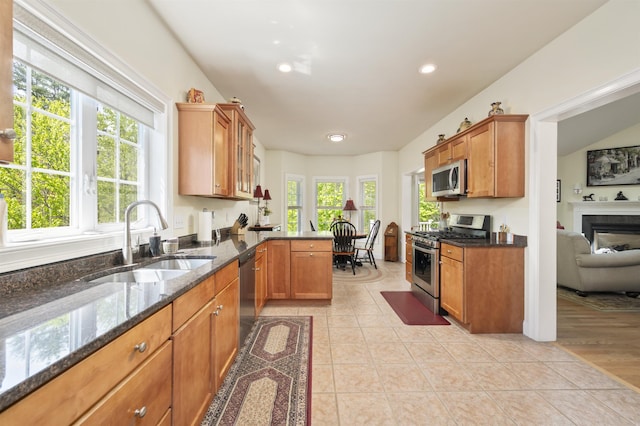 kitchen featuring appliances with stainless steel finishes, a sink, plenty of natural light, brown cabinets, and recessed lighting