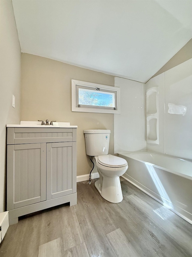 516 Hall St, Bow, NH 03304 - bathroom with toilet, wood finished floors, vaulted ceiling, vanity, and baseboards