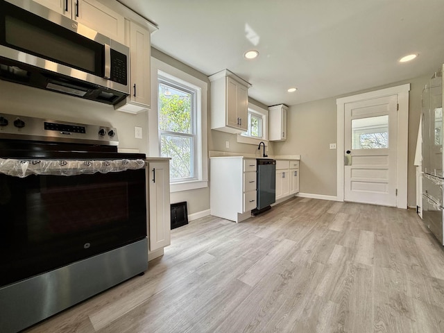 516 Hall St, Bow, NH 03304 - kitchen with appliances with stainless steel finishes, light wood-style flooring, light countertops, baseboards, and white cabinets