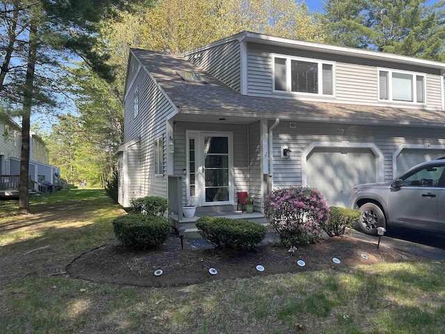 view of front of property with an attached garage and roof with shingles