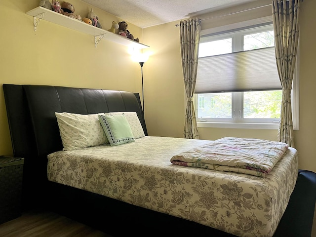 bedroom with wood finished floors and a textured ceiling