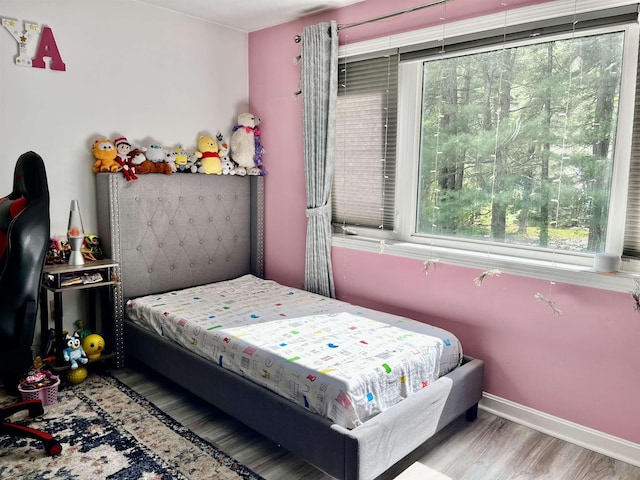 bedroom featuring wood finished floors and baseboards