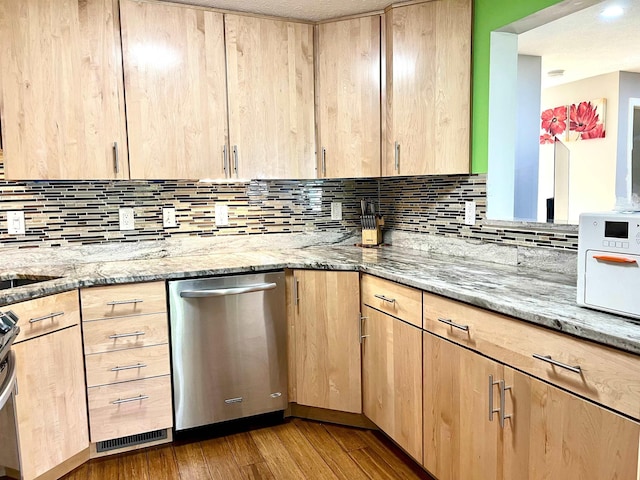 kitchen with light brown cabinets, stainless steel appliances, light stone countertops, wood finished floors, and backsplash