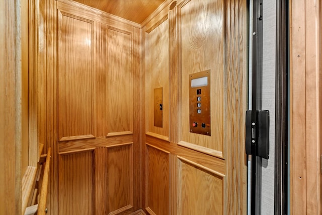 elevator featuring wooden walls