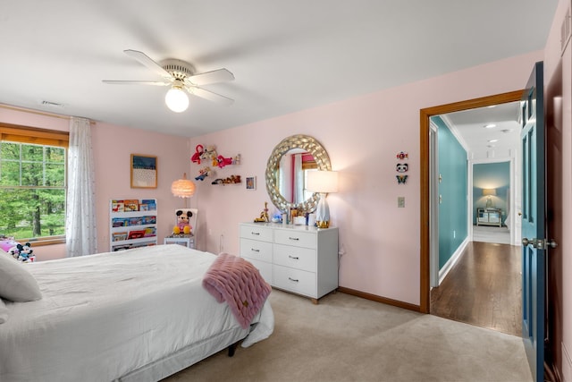 bedroom with light carpet, baseboards, and a ceiling fan