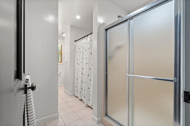 full bath with a stall shower, tile patterned flooring, and baseboards