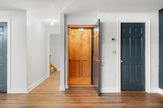 foyer with light wood finished floors and baseboards