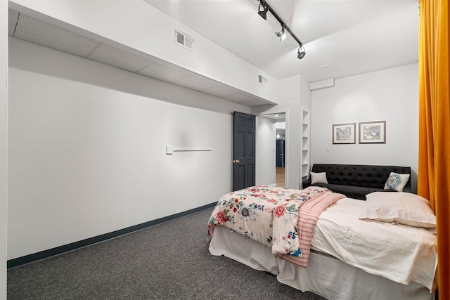 carpeted bedroom with rail lighting and baseboards