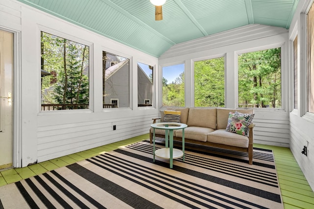sunroom with lofted ceiling, a ceiling fan, and an outdoor hangout area