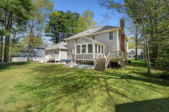 rear view of property featuring a sunroom, stairway, a chimney, and a deck
