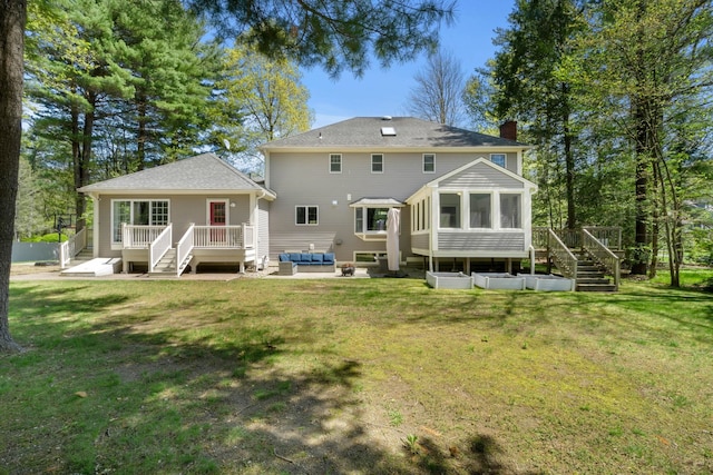back of house featuring outdoor lounge area, a sunroom, stairway, a chimney, and a wooden deck