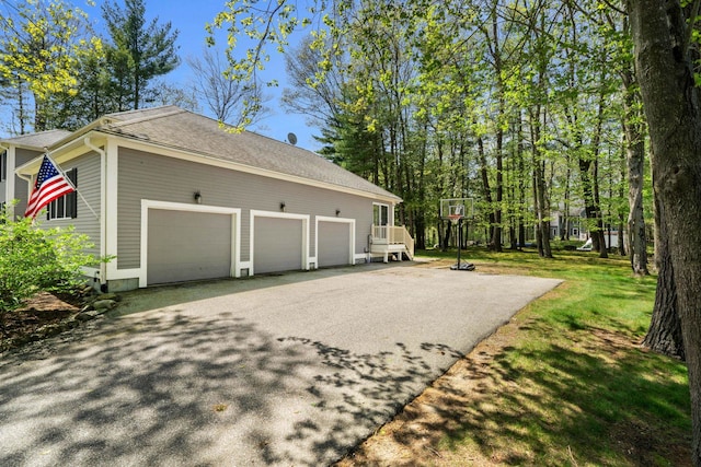 view of side of home with asphalt driveway