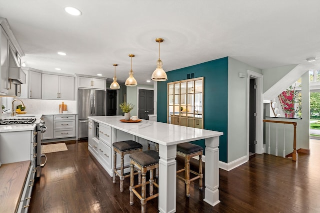 kitchen with stainless steel appliances, recessed lighting, dark wood-type flooring, a center island, and decorative backsplash
