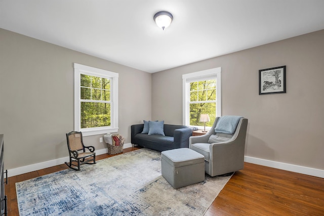 living area featuring healthy amount of natural light, wood finished floors, and baseboards