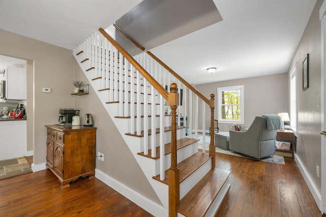 stairway featuring wood-type flooring and baseboards
