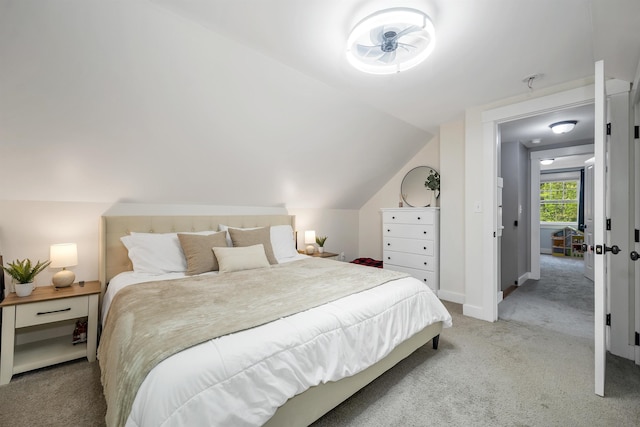 bedroom with light carpet, vaulted ceiling, and baseboards