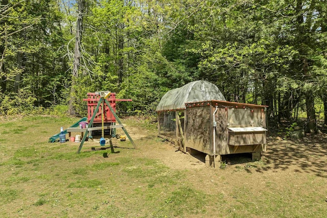 view of jungle gym featuring a yard and a forest view