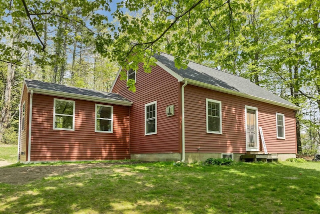 view of front of property with entry steps, a front yard, and roof with shingles