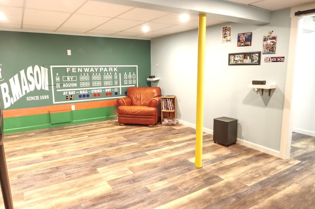 sitting room featuring a paneled ceiling, wood finished floors, and baseboards