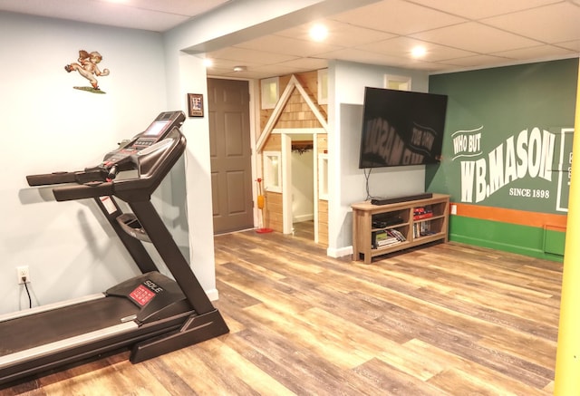 workout room featuring a paneled ceiling and wood finished floors
