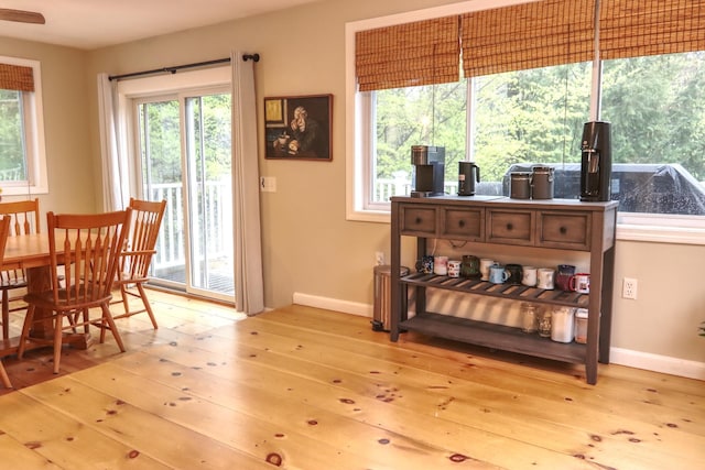 dining space with light wood-style flooring and baseboards