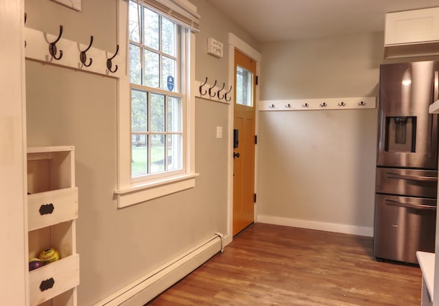 doorway to outside featuring baseboard heating, wood finished floors, and baseboards