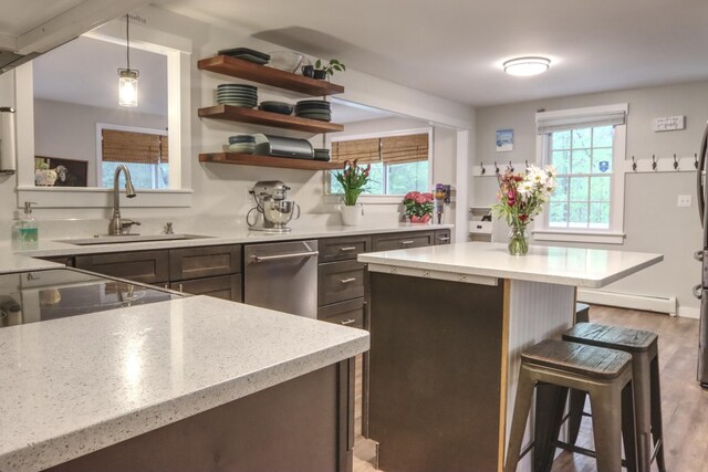 kitchen featuring a sink, a kitchen breakfast bar, healthy amount of natural light, and dishwasher