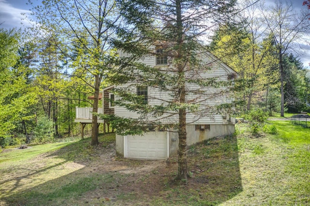 view of side of property featuring an attached garage, dirt driveway, and a yard