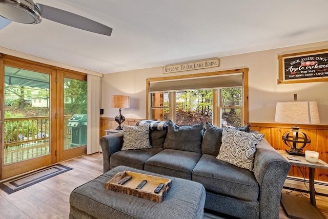 living area featuring a wainscoted wall, a baseboard radiator, wood finished floors, and wooden walls