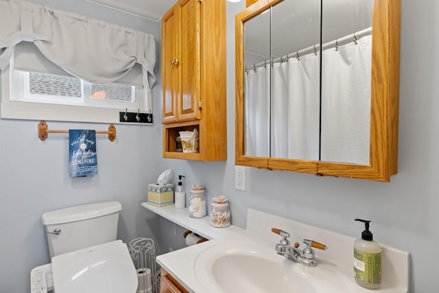 bathroom with toilet, vanity, and a shower with curtain