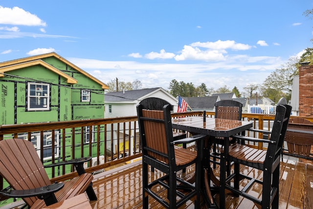 wooden deck featuring outdoor dining area and an outdoor structure
