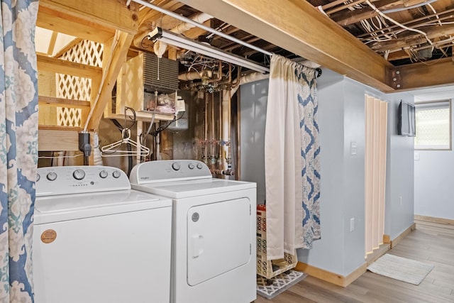 washroom with separate washer and dryer, wood finished floors, and baseboards