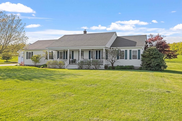 cape cod-style house with a porch, a chimney, a front yard, and roof with shingles