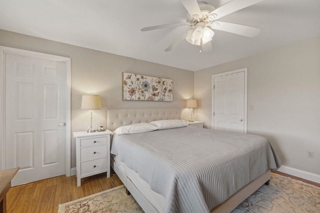 bedroom featuring light wood-type flooring, baseboards, and ceiling fan