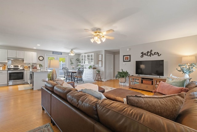 living area featuring a ceiling fan, light wood finished floors, and recessed lighting
