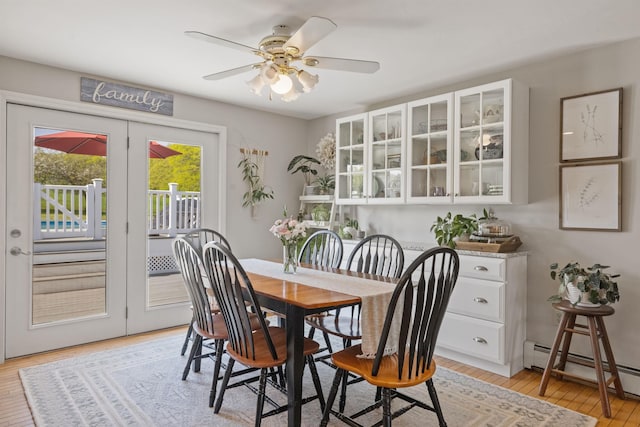 dining room with baseboard heating, light wood finished floors, and a ceiling fan