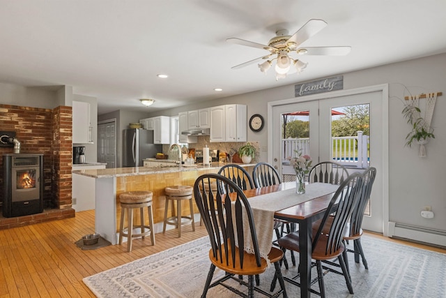 dining area featuring a baseboard radiator, light wood finished floors, a ceiling fan, and recessed lighting