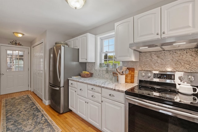 kitchen with stainless steel appliances, under cabinet range hood, light wood-style flooring, decorative backsplash, and white cabinets