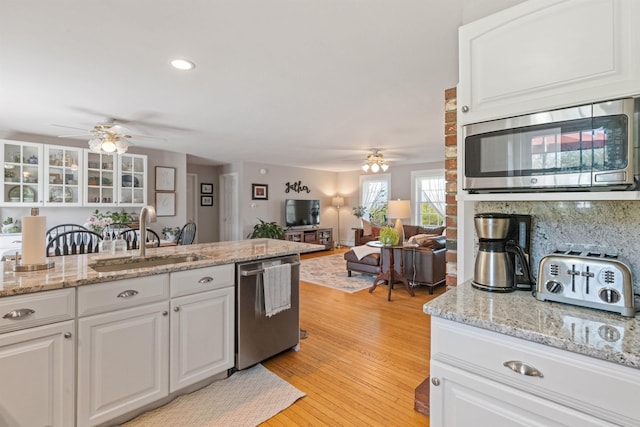 kitchen with appliances with stainless steel finishes, ceiling fan, a sink, white cabinets, and recessed lighting