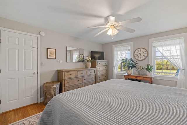 bedroom with light wood-style floors and a ceiling fan