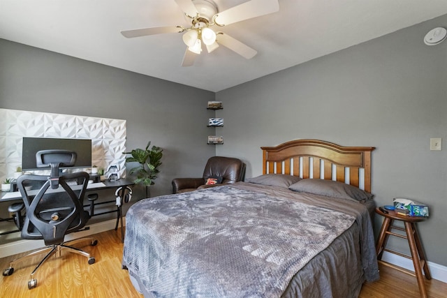 bedroom with wood finished floors, baseboards, and a ceiling fan