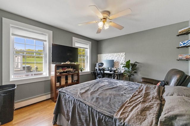 bedroom featuring a baseboard radiator, wood finished floors, and a ceiling fan