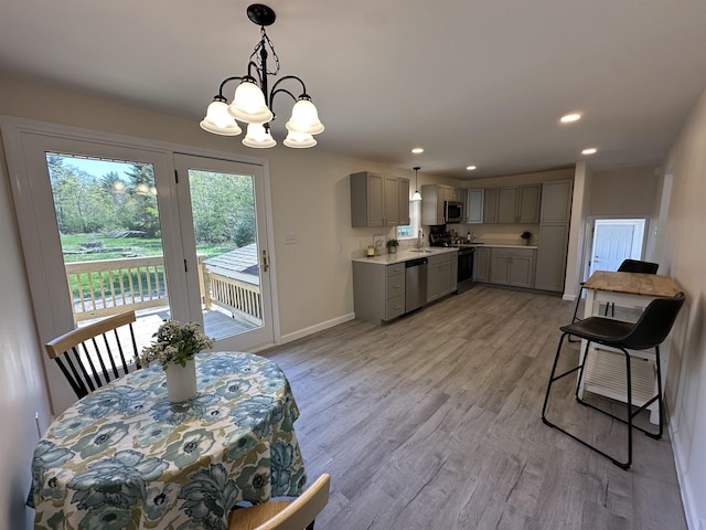 dining space with a chandelier, light wood-type flooring, recessed lighting, and baseboards