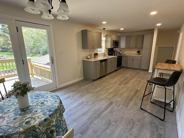 kitchen featuring gray cabinets, stainless steel appliances, plenty of natural light, a sink, and recessed lighting